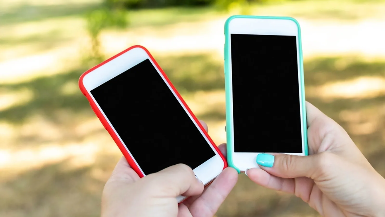 Two smartphones with blank screens held up side by side