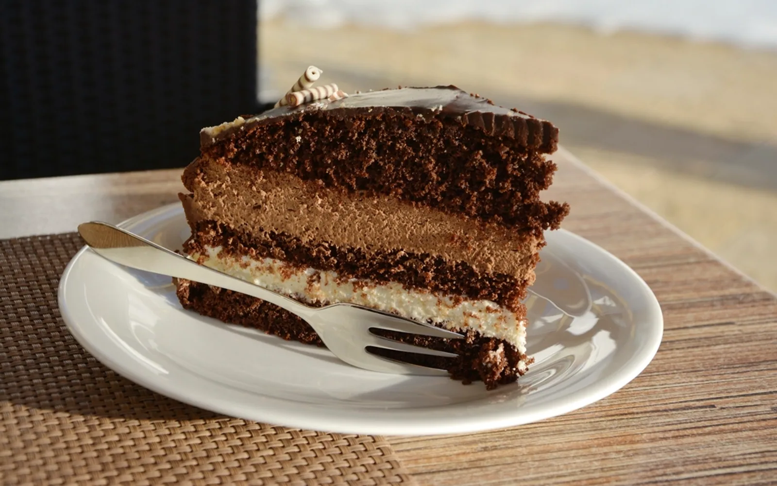 Slice of layered chocolate cake on a white plate